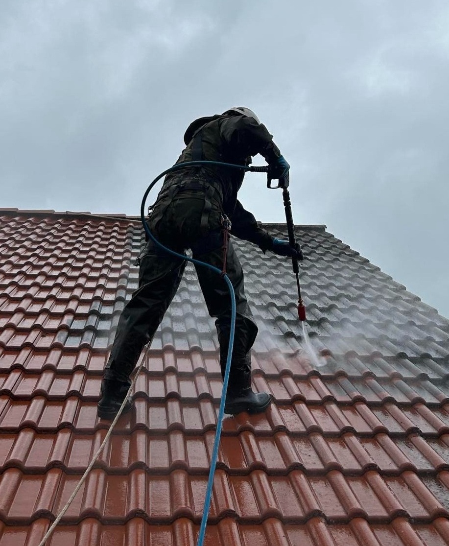 Professionelle Dachreinigung mit sichtbarem Reinigungsergebnis auf einem Ziegeldach
